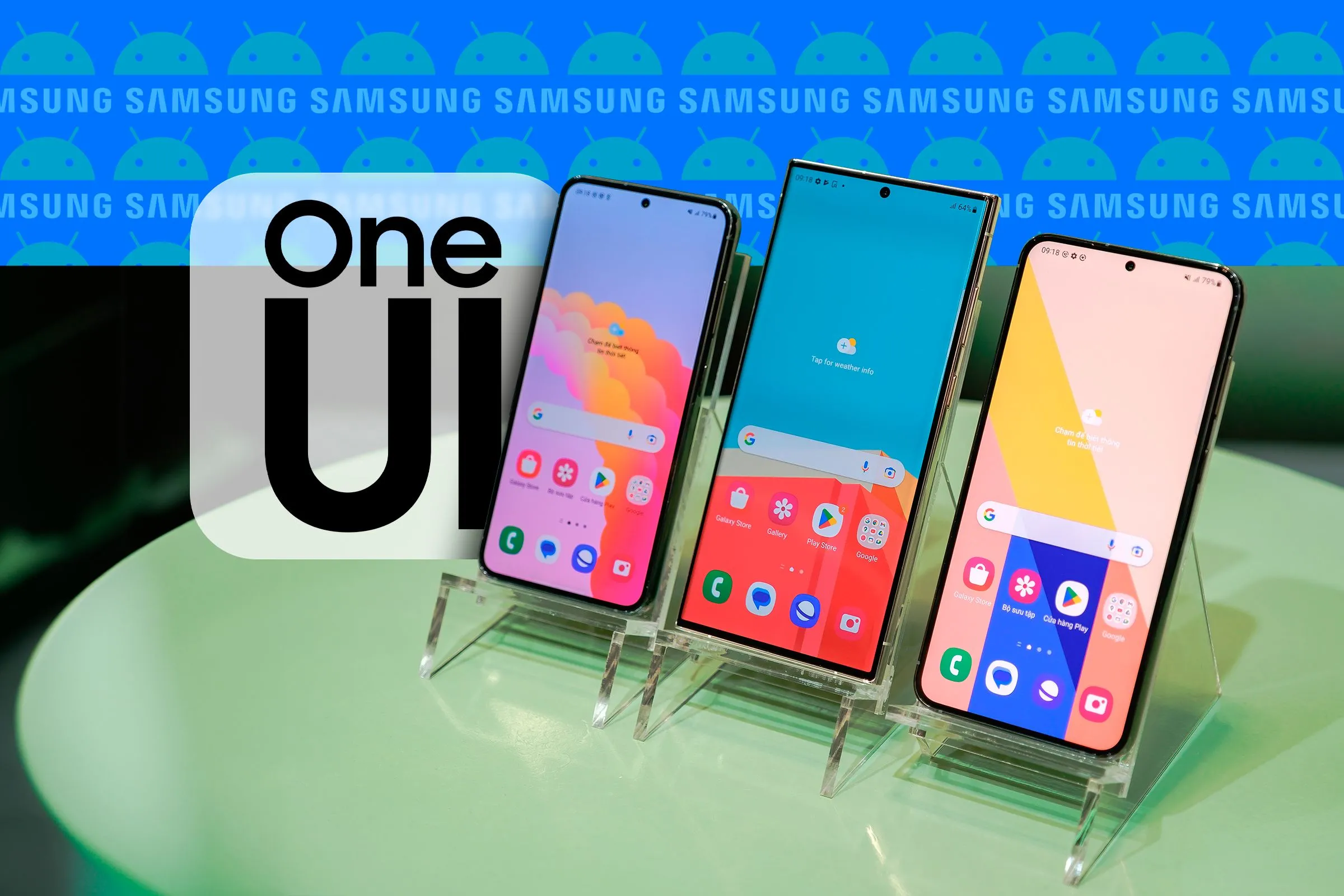 Ba điện thoại Samsung đặt cạnh nhau hiển thị giao diện One UI, cùng với logo One UI và logo Samsung, Android ở hậu cảnh, thể hiện sự nhận diện thương hiệu và thiết kế hiện đại của One UI.