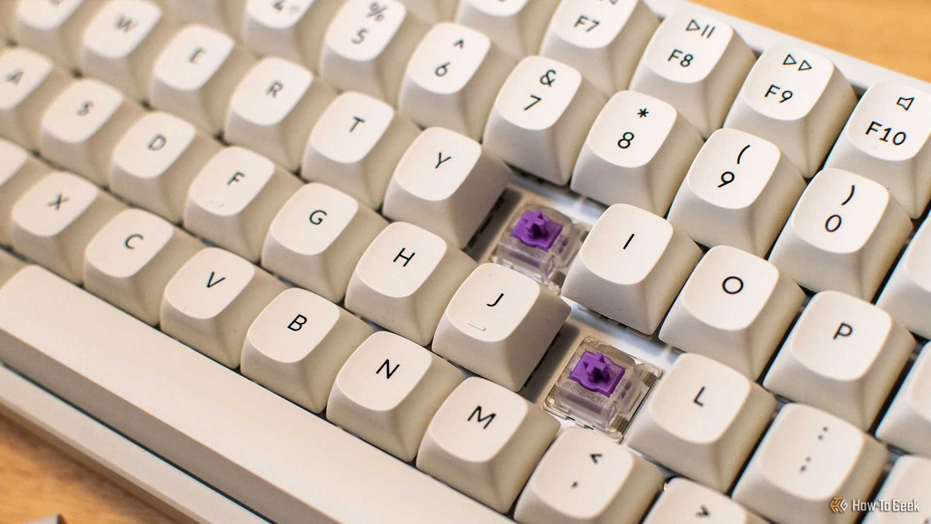 Bàn phím Keychron K4 HE với hai keycap được tháo ra, để lộ switch từ tính Gateron Dual-rail Magnetic Nebula màu xanh lá cây bên dưới.