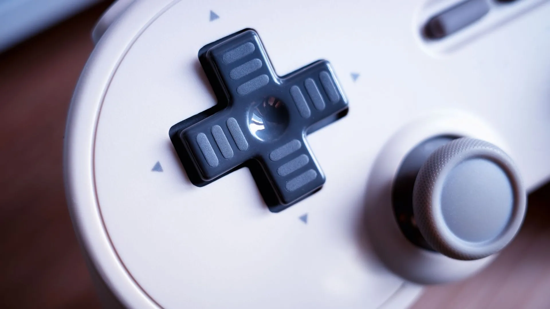 cận cảnh tay cầm chơi game cổ điển với phím D-Pad màu đen, chi tiết về hệ thống điều hướng chính xác của Nintendo