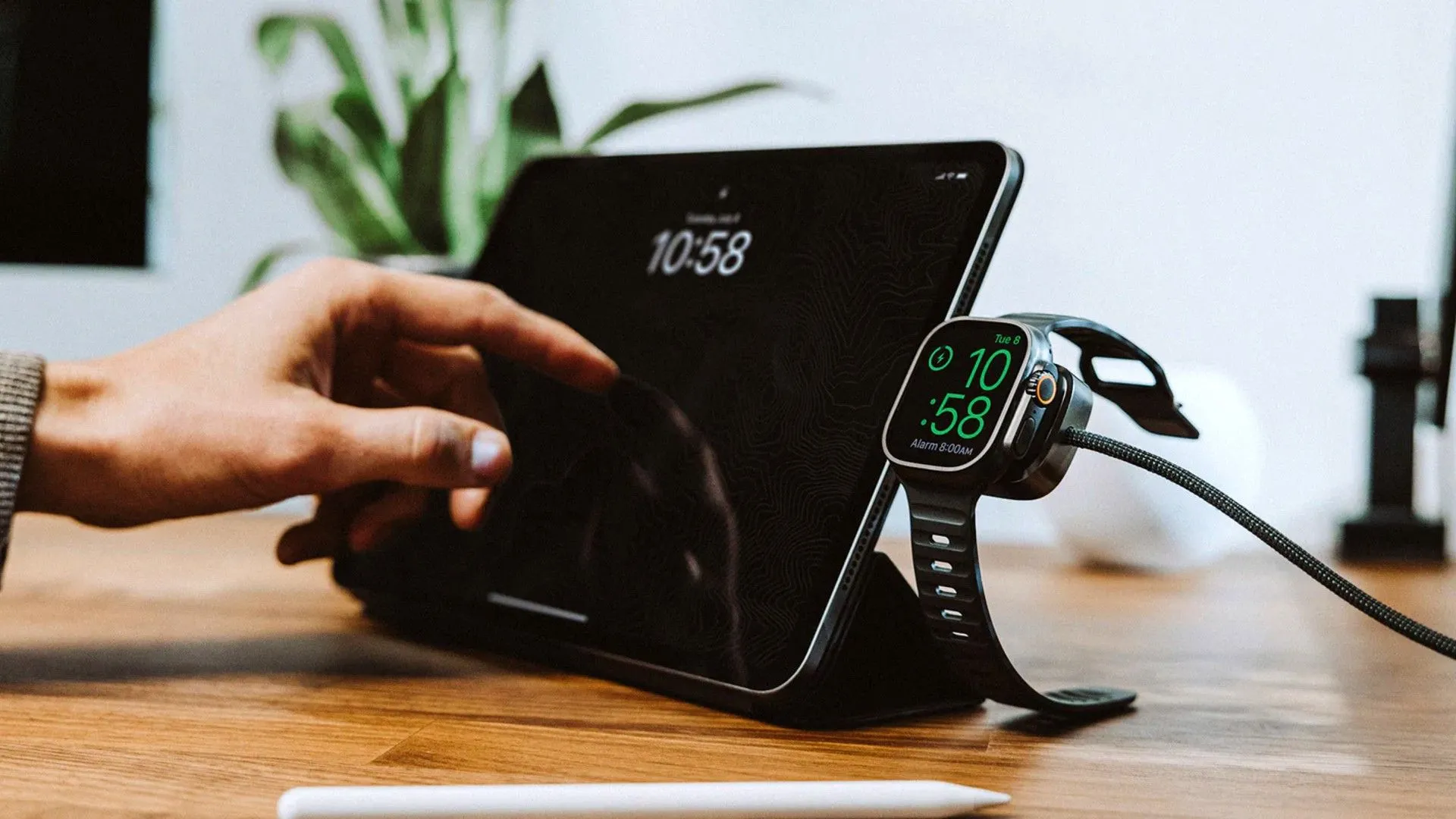Cáp sạc đa năng Nomad Universal Cable dành cho Apple Watch và thiết bị USB-C đang được sử dụng.