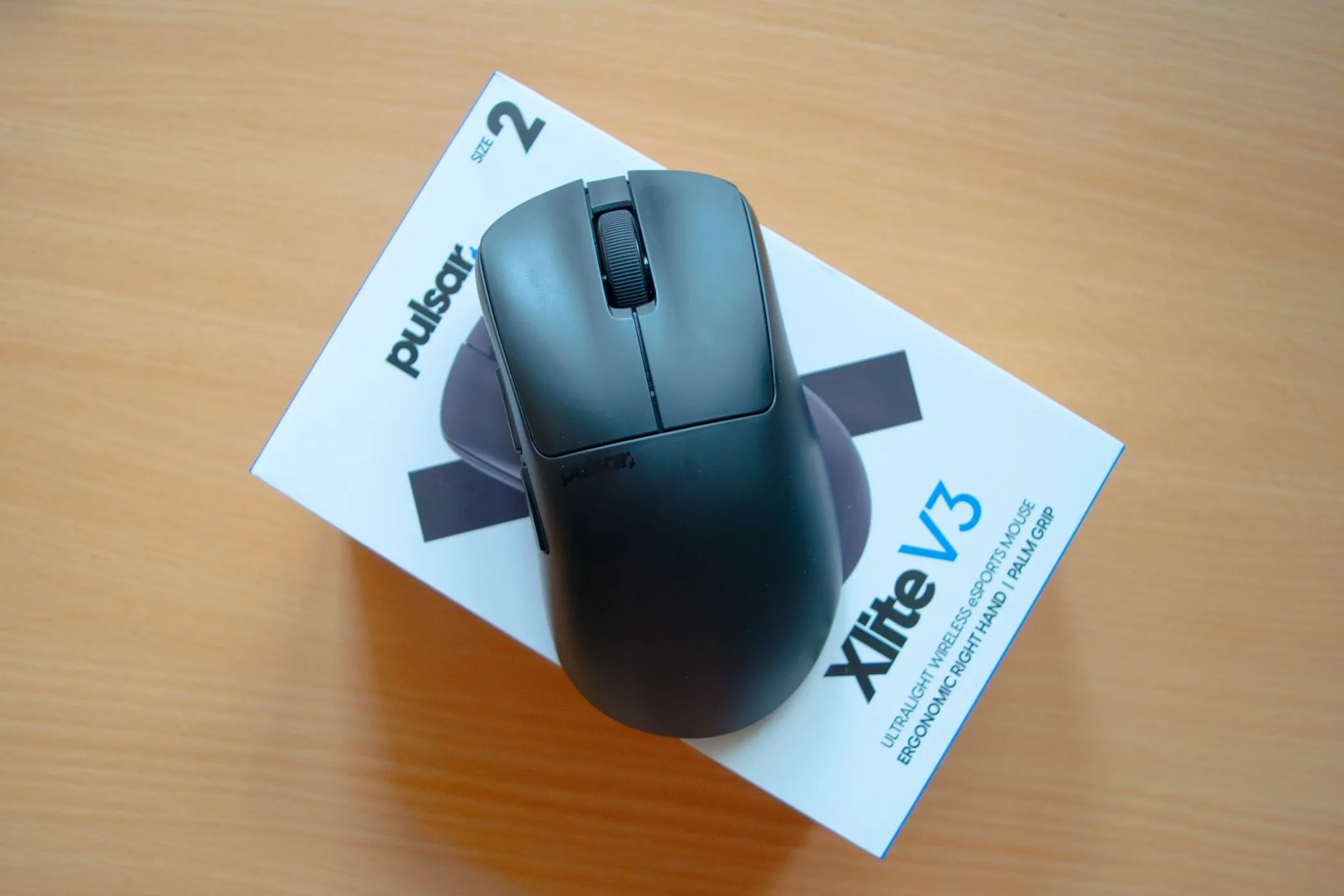 Chuột gaming Pulsar Xlite V3 màu đen đặt trên hộp đựng, thể hiện thiết kế tổng thể
