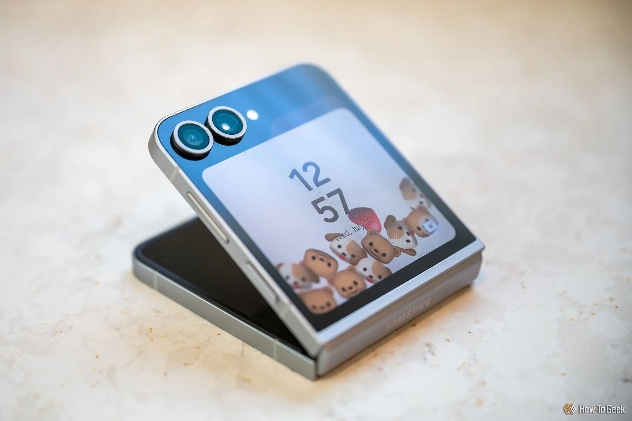 Điện thoại Samsung Galaxy Z Flip 6 gập một nửa hiển thị màn hình khóa, minh họa thiết kế gập vỏ sò