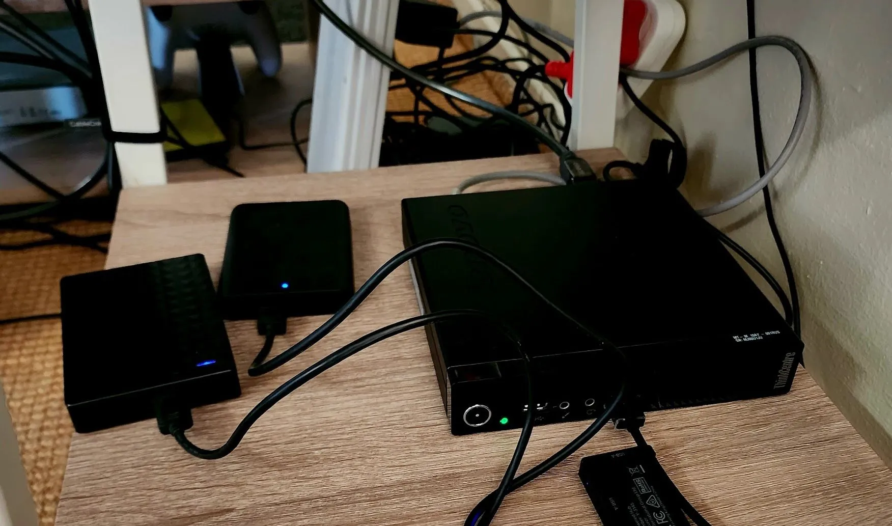 Hệ thống Plex server mini PC với nhiều ổ cứng USB mở rộng, đặt gọn trên kệ bàn.