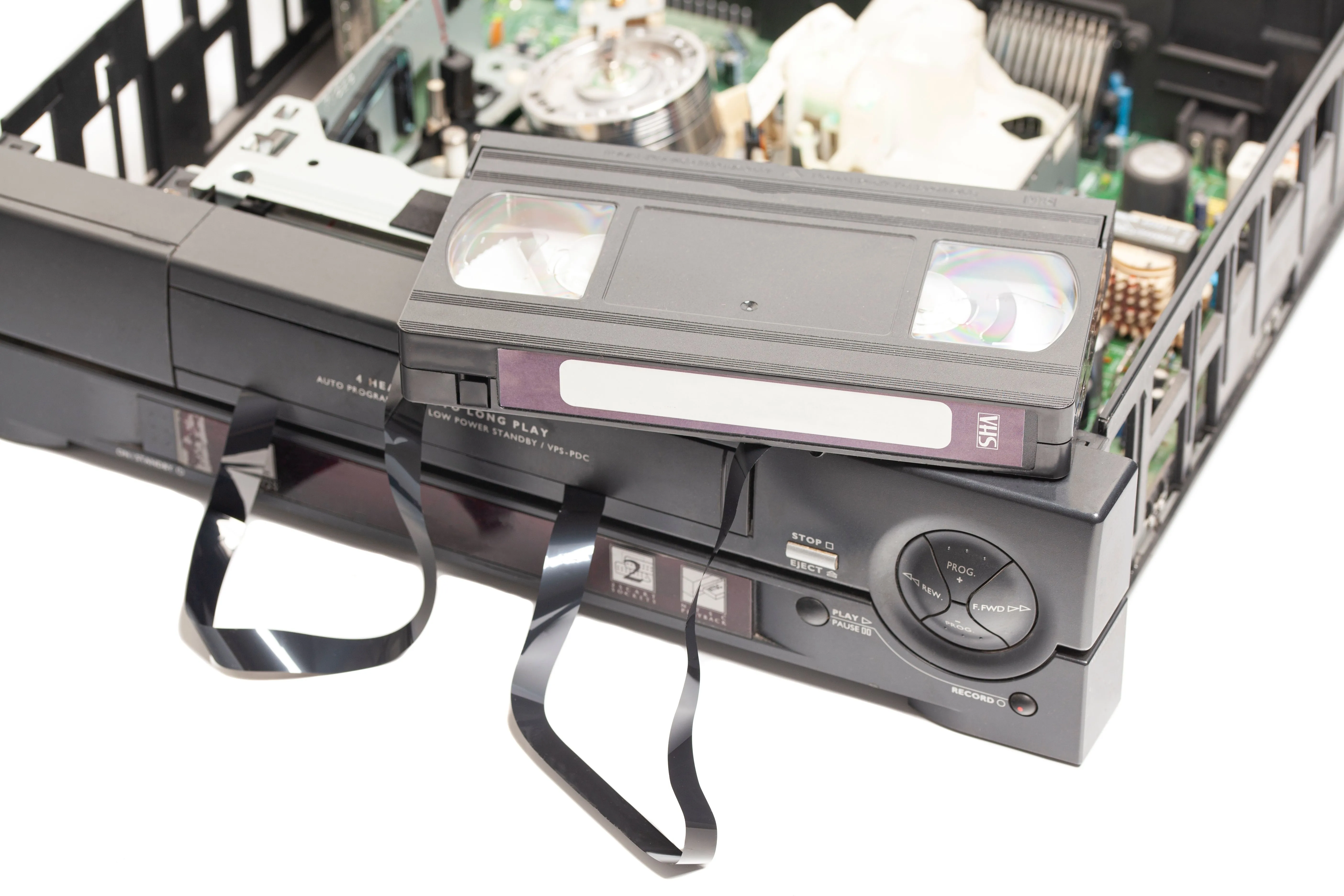 Hình ảnh mô tả băng VHS bị kẹt và hỏng trong đầu VCR, một vấn đề phổ biến của công nghệ xem phim giải trí cũ.