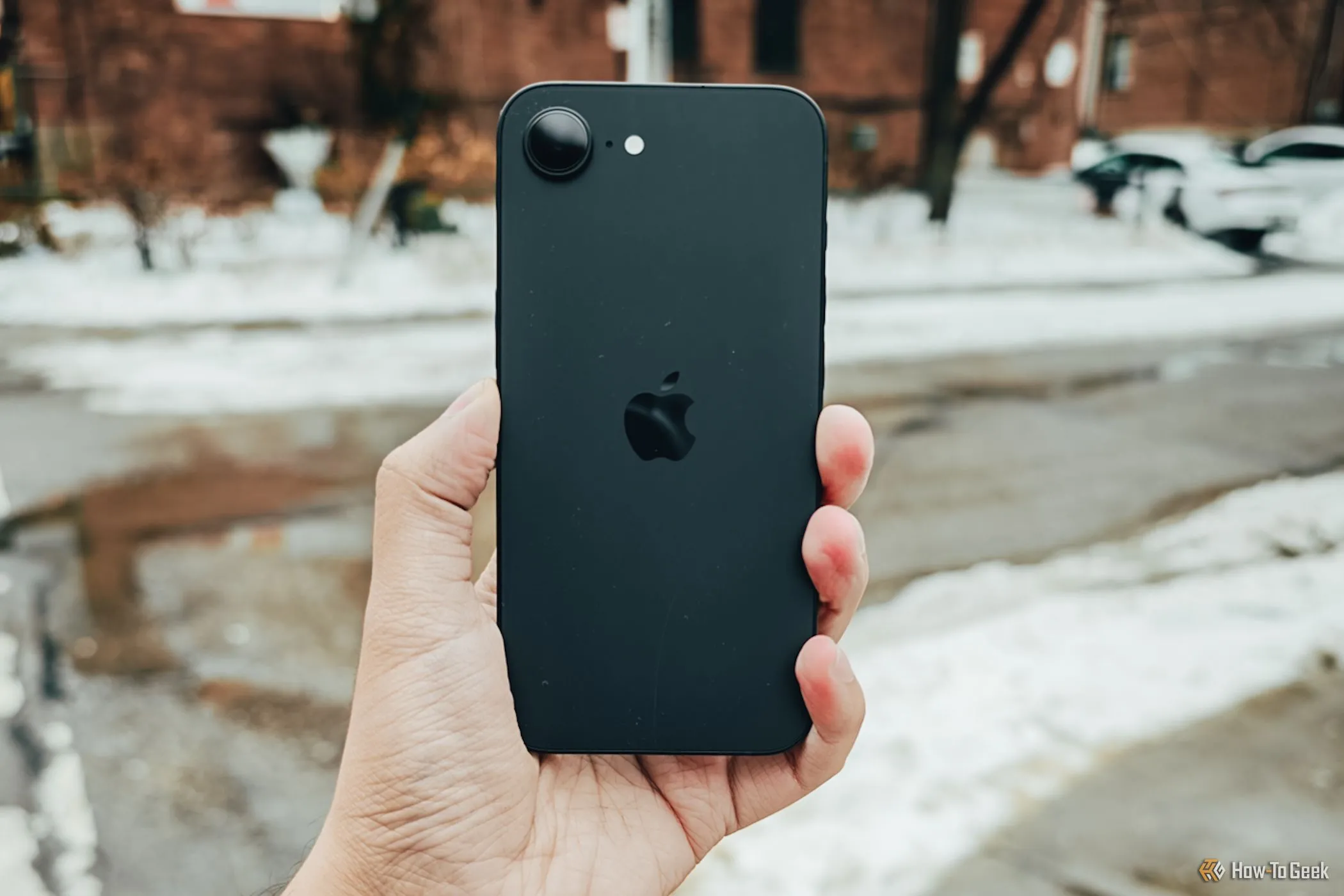 iPhone 16e đang được cầm trên tay ngoài trời, biểu tượng của sự tiện lợi và giá cả phải chăng