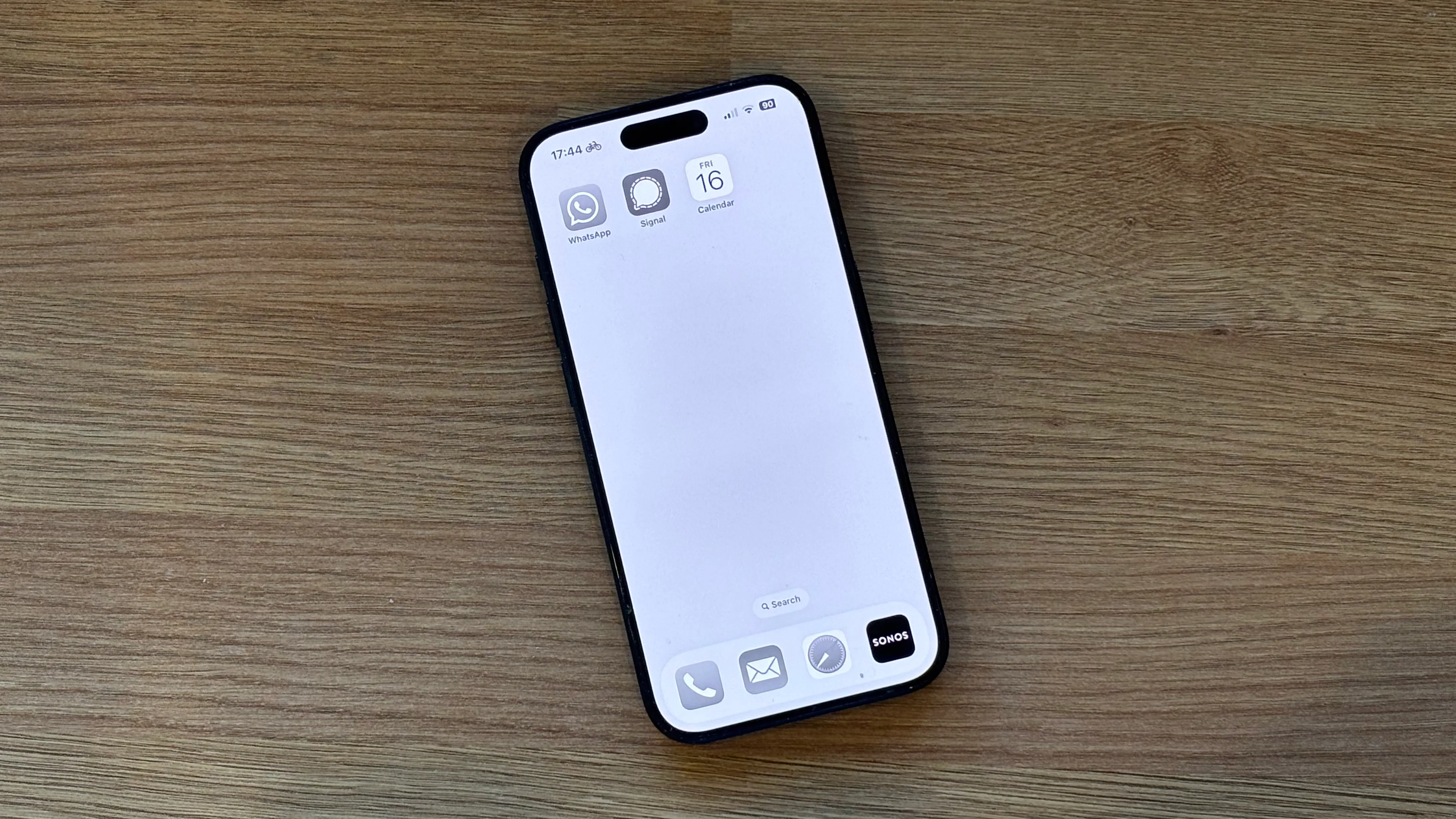 Màn hình chính iPhone hiển thị chế độ xám (grayscale) với ba ứng dụng chính.