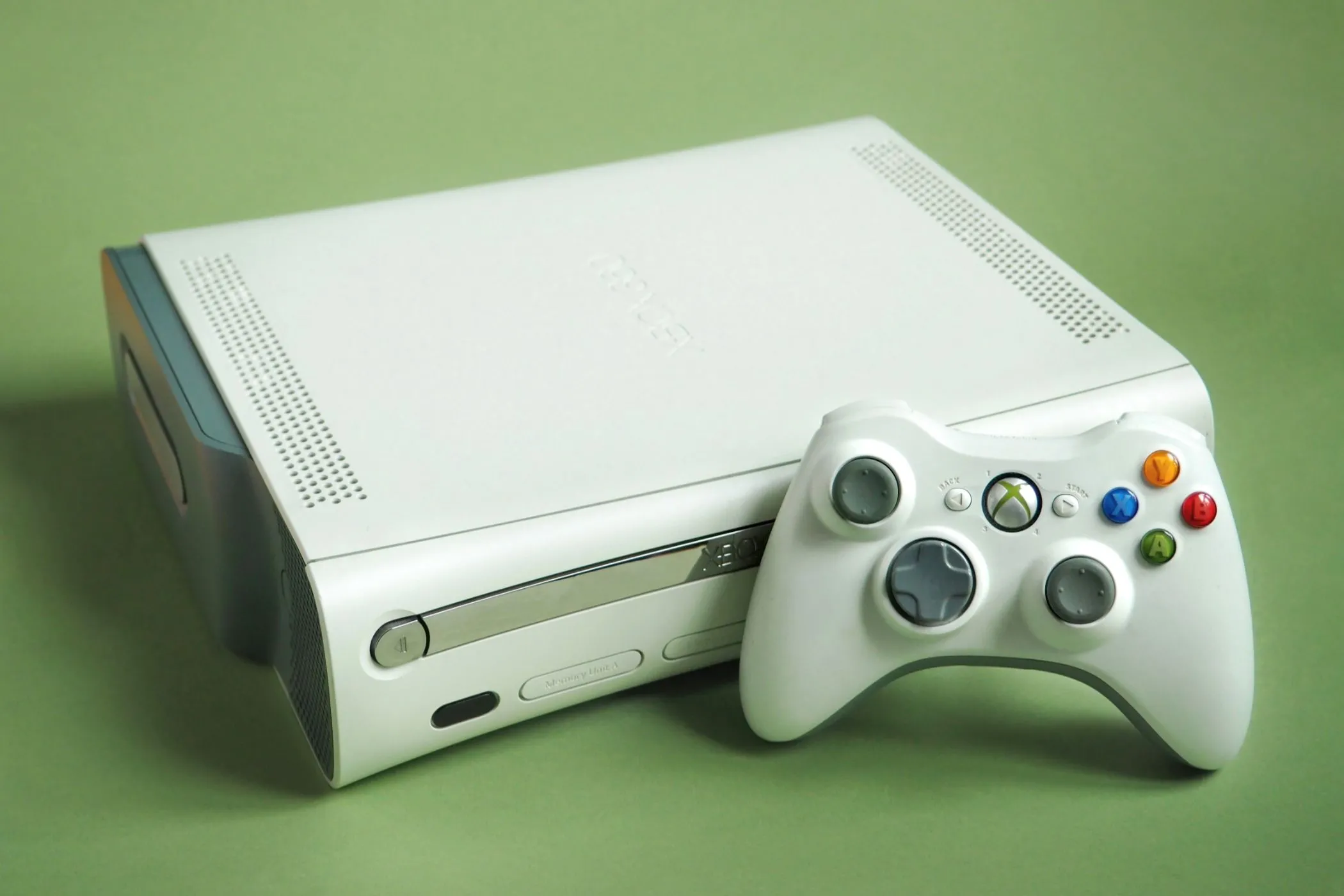 Máy chơi game Xbox 360 màu trắng cùng tay cầm, biểu tượng của kỷ nguyên thành tích game hiện đại.