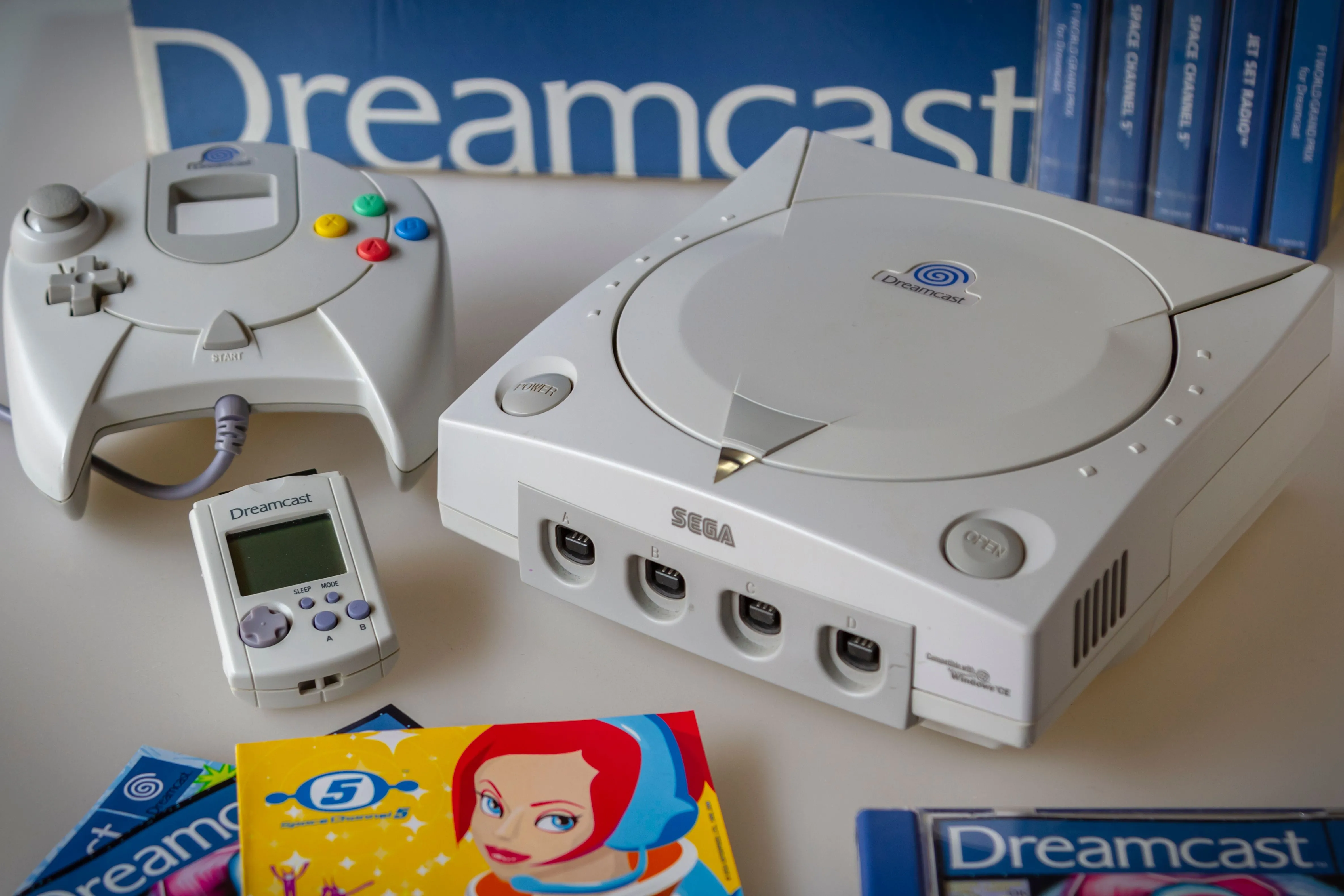 Máy console Sega Dreamcast với tay cầm và đĩa game Space Channel 5, biểu tượng của sự sáng tạo trong kỷ nguyên game tầm trung.
