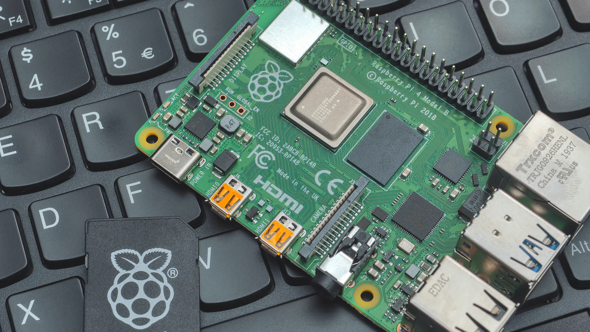 Một bo mạch Raspberry Pi 4 đặt cạnh laptop ThinkPad, minh họa khả năng thay thế máy tính xách tay gọn nhẹ