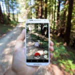 Người chơi tận hưởng Pokémon GO trên điện thoại thông minh, tương tác với môi trường thực thông qua công nghệ thực tế tăng cường (AR) dựa trên vị trí.