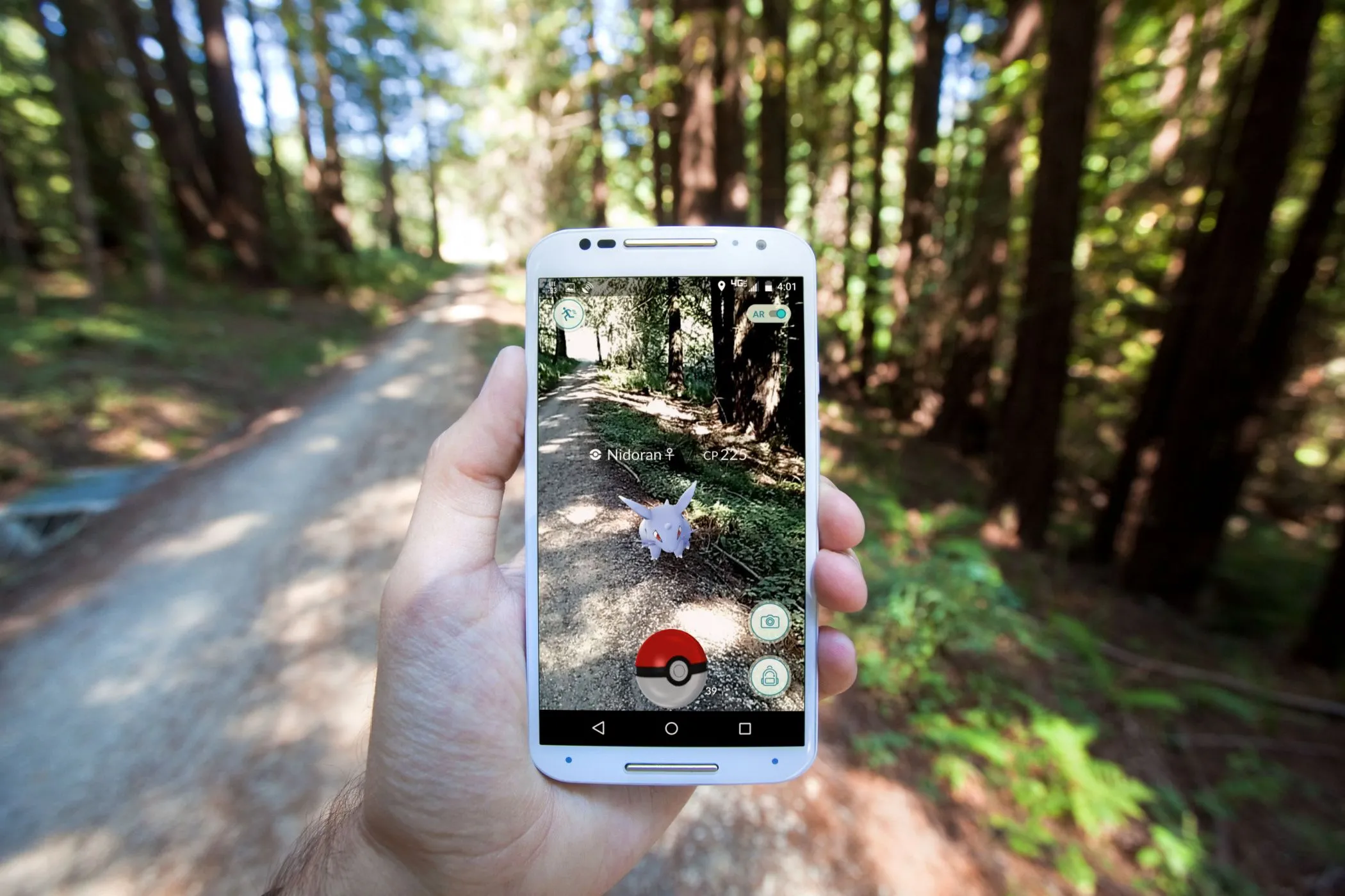 Người chơi tận hưởng Pokémon GO trên điện thoại thông minh, tương tác với môi trường thực thông qua công nghệ thực tế tăng cường (AR) dựa trên vị trí.