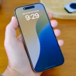 Người dùng đang cầm iPhone 16 Pro màu titan hiển thị màn hình Super Retina XDR
