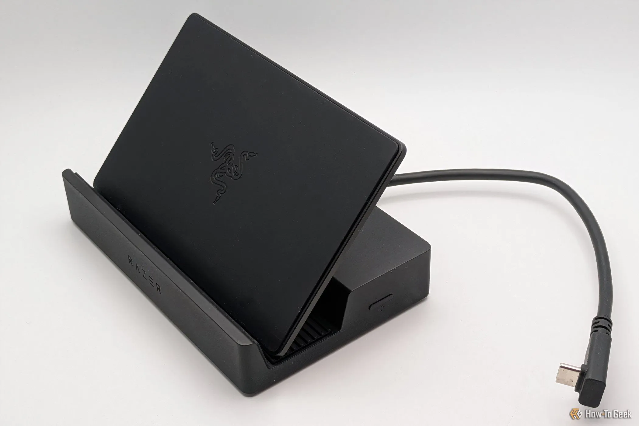 Razer Handheld Dock Chroma ở trạng thái dựng đứng, sẵn sàng kết nối với thiết bị chơi game cầm tay.