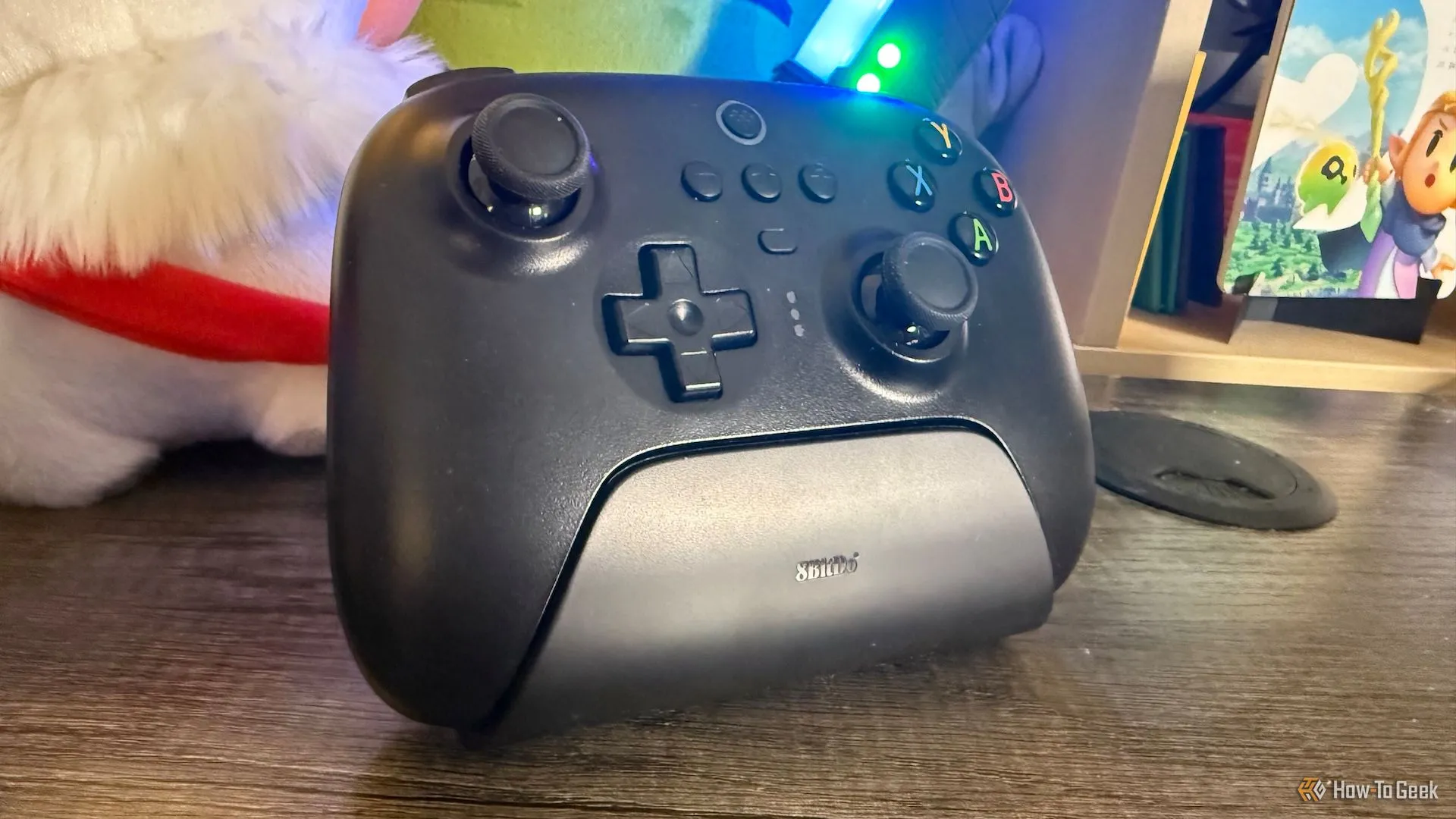 Tay cầm 8BitDo Ultimate 2.4G màu đen đang đặt trên dock sạc tiện lợi.